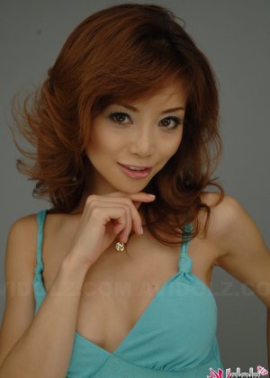 Рыжеволосая японка Аканэ Хотару расплывается в улыбке, моделируя длинное платье